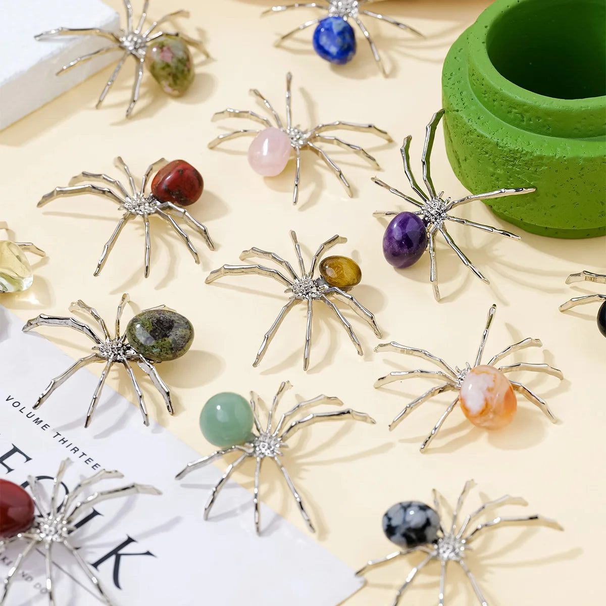 A collection of handcrafted crystal spider figurines in various colors and sizes displayed on a light background.