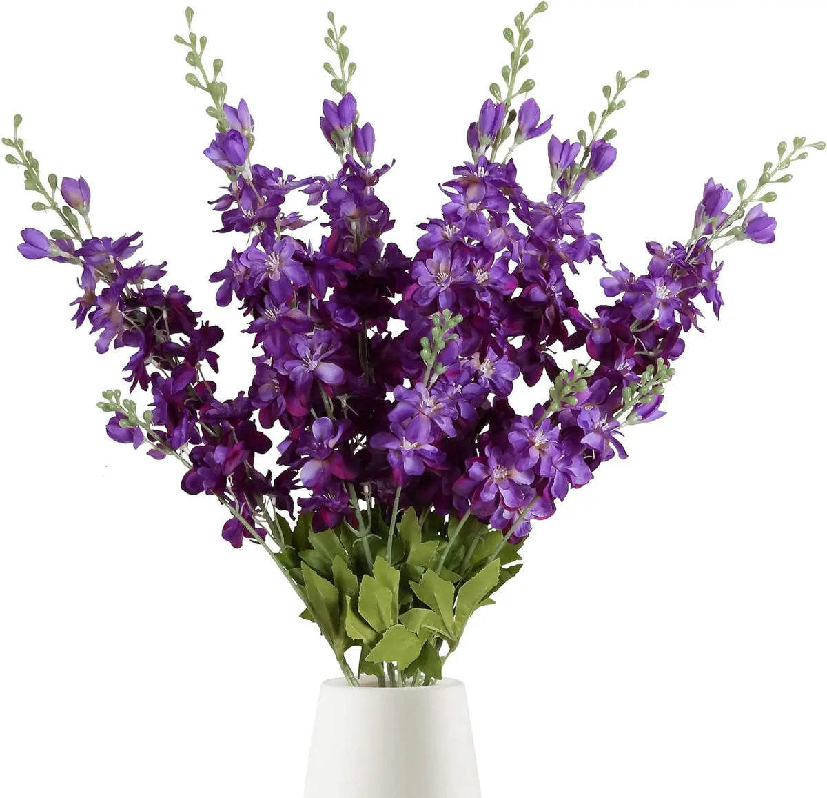 Un bouquet de fleurs artificielles de delphinium violet avec du feuillage vert dans un pot blanc.