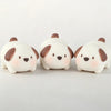 Three white pig mochi squishy toys with brown ears resting on a white surface.