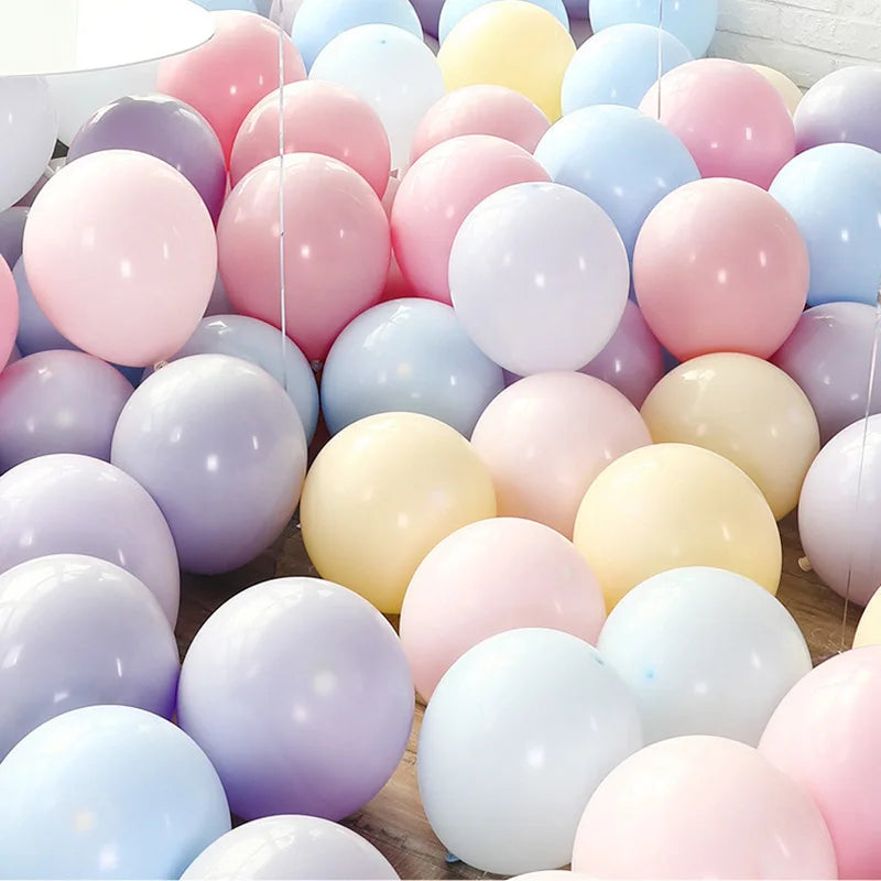 A close-up of assorted pastel macaron balloons in various shades including pink, purple, yellow, and blue.