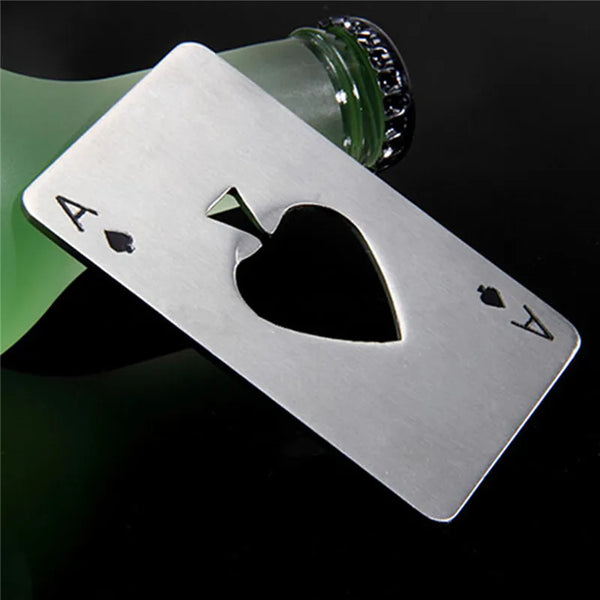 Stainless steel bottle opener shaped like a spade, resting near a green glass bottle.