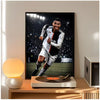 A framed poster of Cristiano Ronaldo in a soccer uniform displayed on a wooden table.