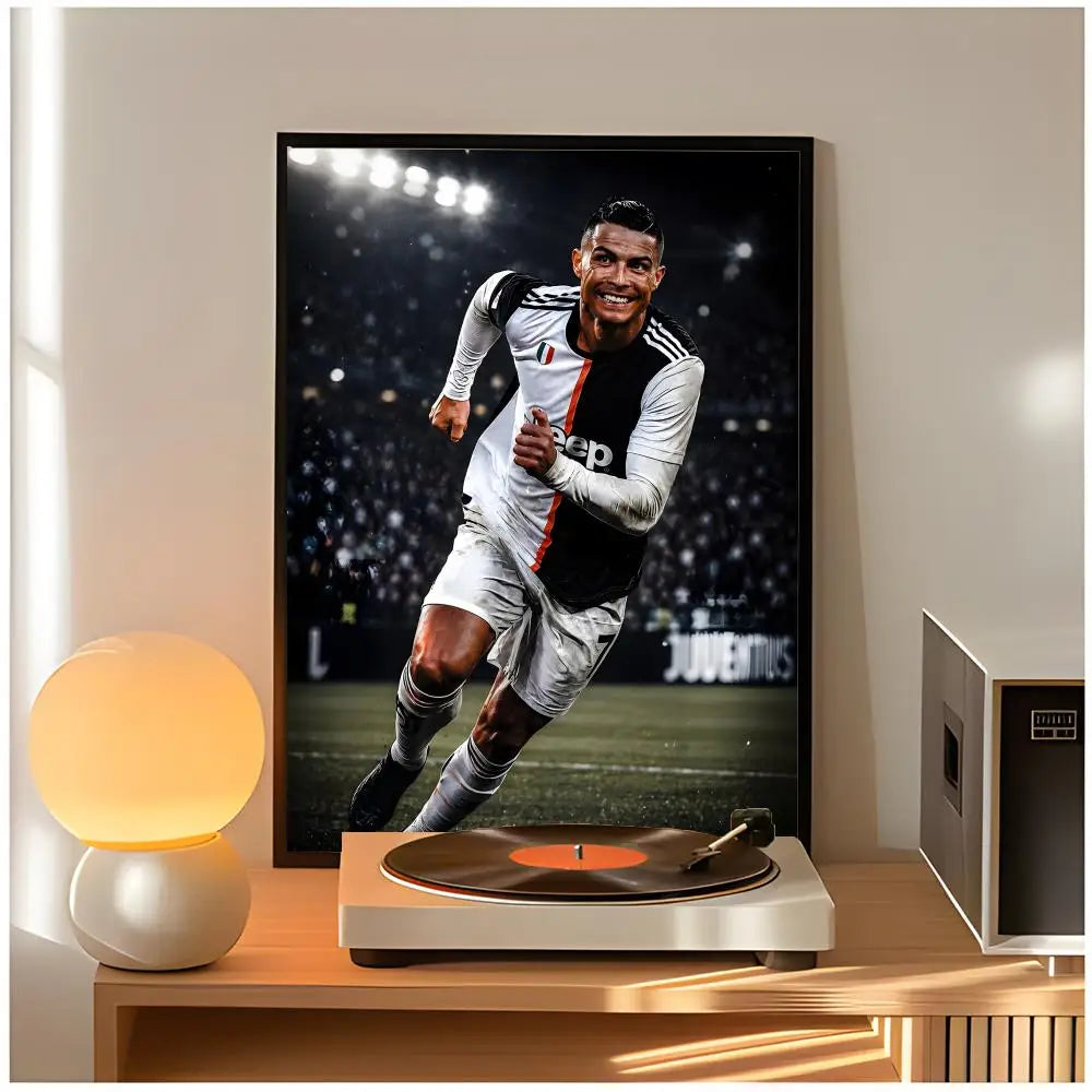A framed poster of Cristiano Ronaldo in a soccer uniform displayed on a wooden table.