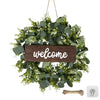 Artificial eucalyptus wreath with green leaves and white flowers featuring a wooden welcome sign
