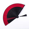A traditional Chinese folding fan with red and black pleated paper blades.