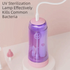 A purple electric baby bottle cleaning brush with a white handle and storage case is shown on a white surface.