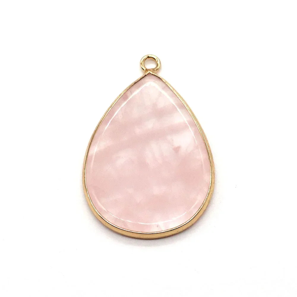 A teardrop-shaped pink agate and rose quartz pendant charm with a gold-colored bail.