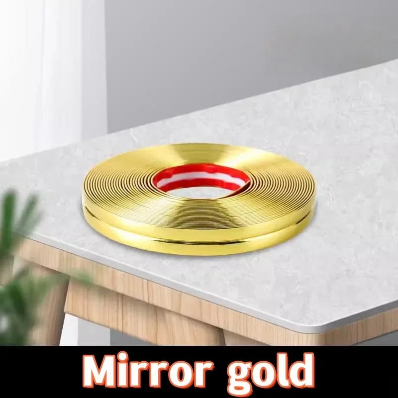 A round mirror gold edge guard strip with a red accent, placed on a light-colored table surface.