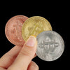 Una mano sostiene tres monedas conmemorativas de Bitcoin: rosa, oro y plata.
