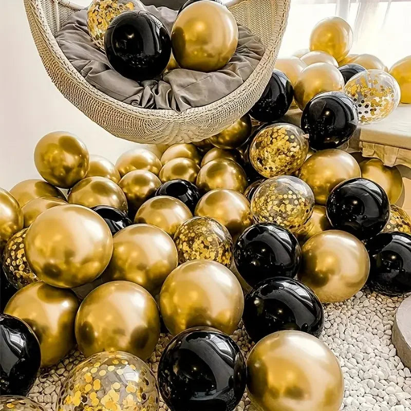 A collection of black and gold confetti balloons is displayed in a woven basket.