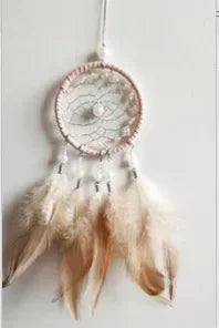 A feather pendant charm featuring a circular mirror design and soft, light brown feathers.