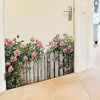 A wooden fence wall decal featuring pink roses and green foliage on a white door.