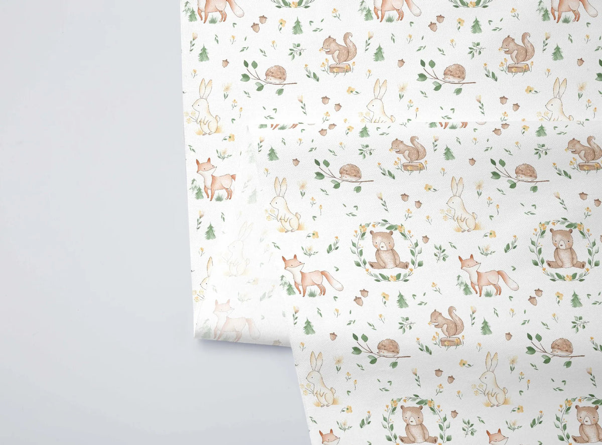 A fabric print featuring a delicate floral pattern with woodland animals like rabbits, squirrels, and deer on a light backgro