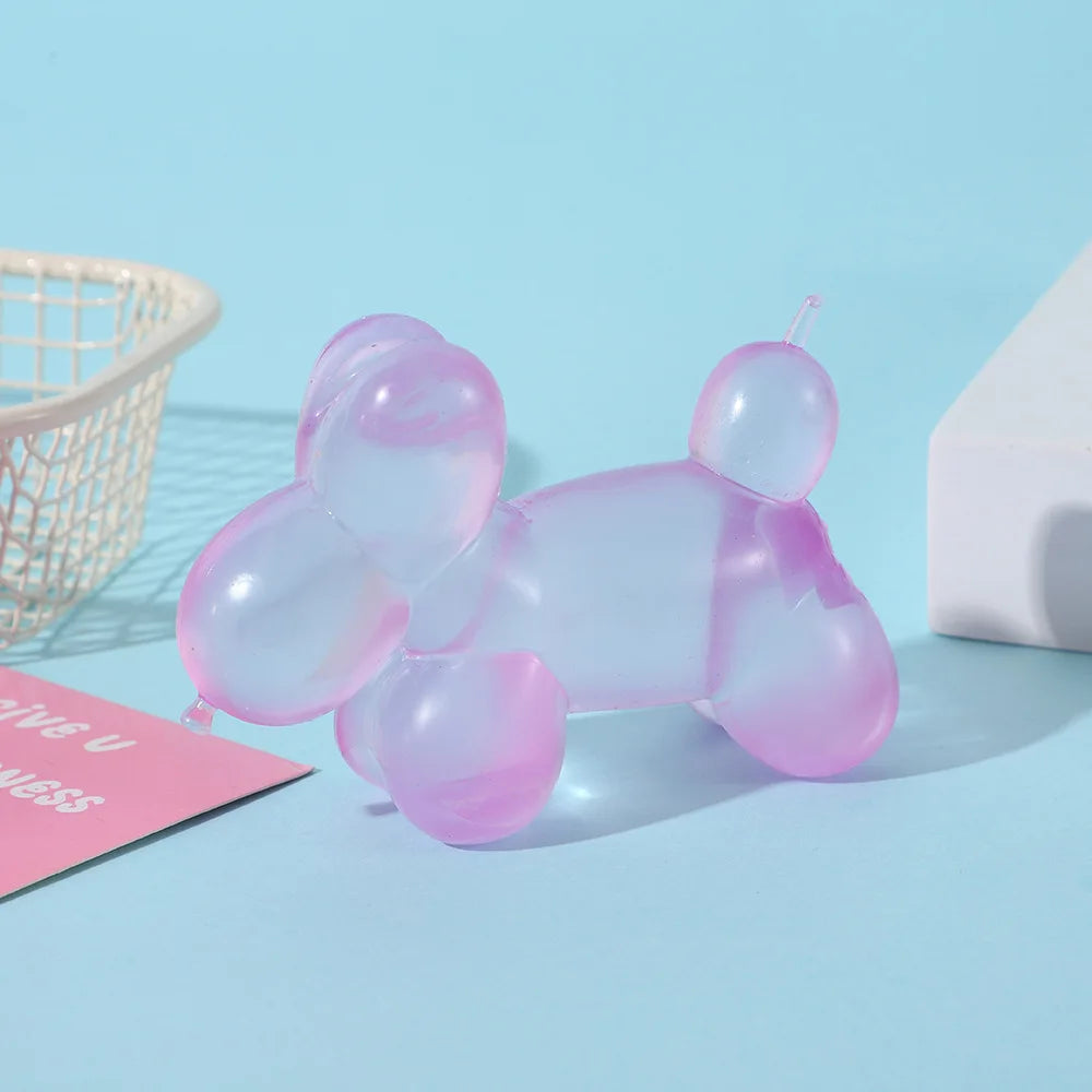 A translucent pink squishy toy shaped like a dachshund lying down on a light blue surface.