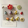A set of ten colorful, floral-shaped fridge magnets featuring bees and flowers on a white card.