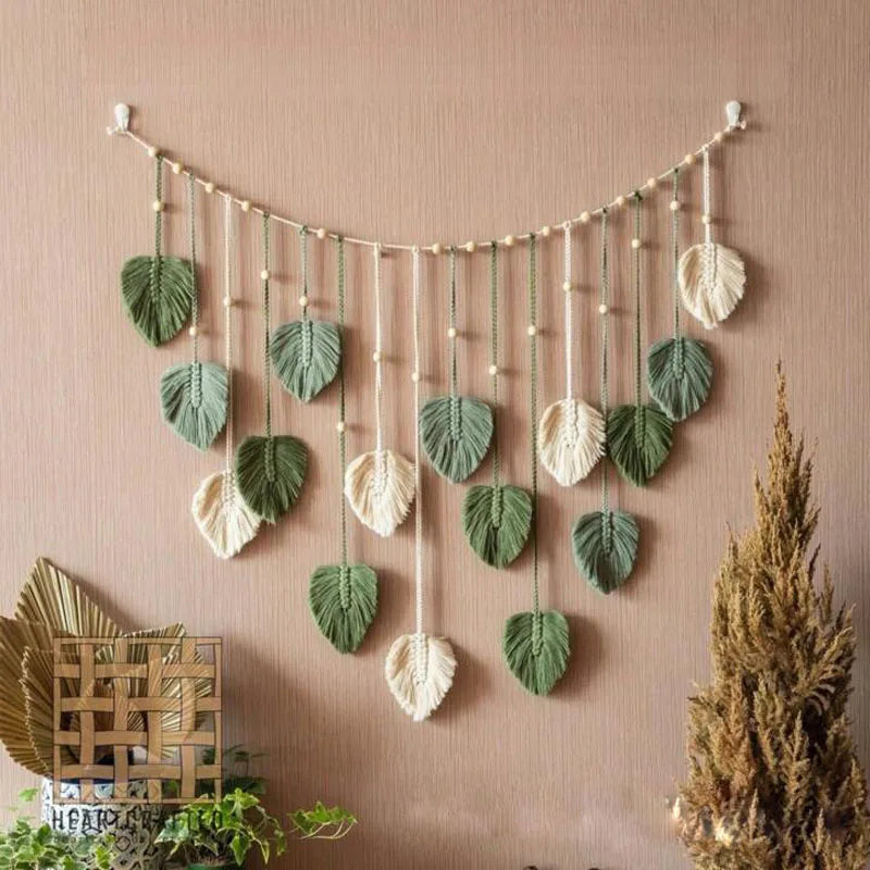 Bohemian macrame leaf wall hanging featuring various sized green and cream leaves with tassels.