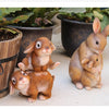 A hand-painted resin rabbit garden statue featuring a mother rabbit and her baby sitting on a light surface.