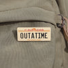 A rectangular enamel pin featuring the text CALIFORNIA OUTATIME The Golden State on a light background