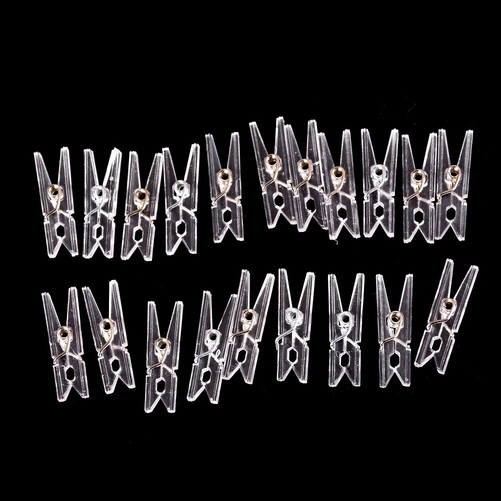 A row of one hundred mini clear plastic spring clips for photos, papers, and crafts.