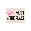 Pink and black text on a beige background reads This Must Be The Place