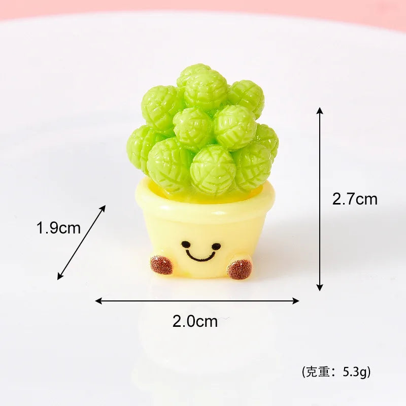 A small yellow resin charm shaped like a smiling face with green textured balls on top.