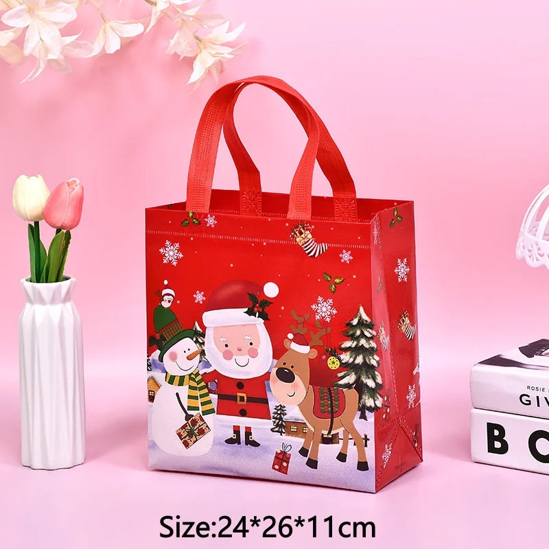 A red non-woven gift tote bag with a festive Christmas print featuring Santa, reindeer, and a Christmas tree.
