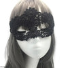 A black lace floral eye mask worn by a model against a white background.