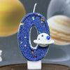 A blue glitter number zero candle decorated with stars and a white planet design.