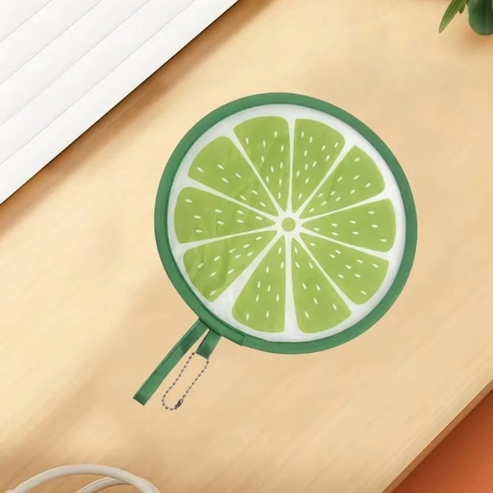 A round, green citrus fruit design is visible on a light wooden surface.