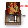 A hand-cranked wooden music box featuring an illustration of two characters, one with red hair and the other with orange hair