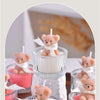A collection of soy wax teddy bear candles in glass jars with ribbons, featuring pink and blue colors.