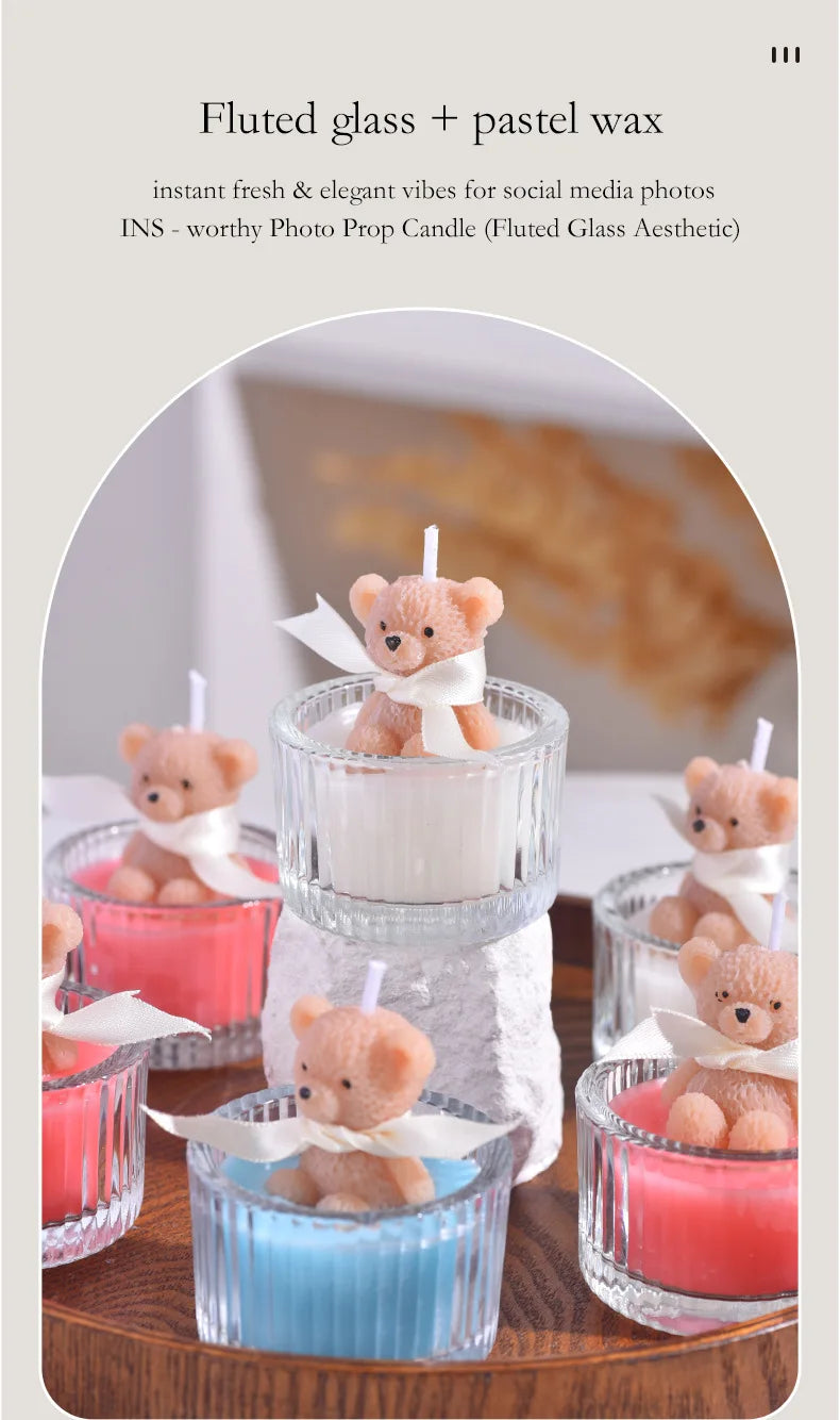 A collection of soy wax teddy bear candles in glass jars with ribbons, featuring pink and blue colors.
