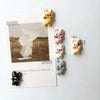 A set of mini puppy refrigerator magnets in various pastel colors and sizes.
