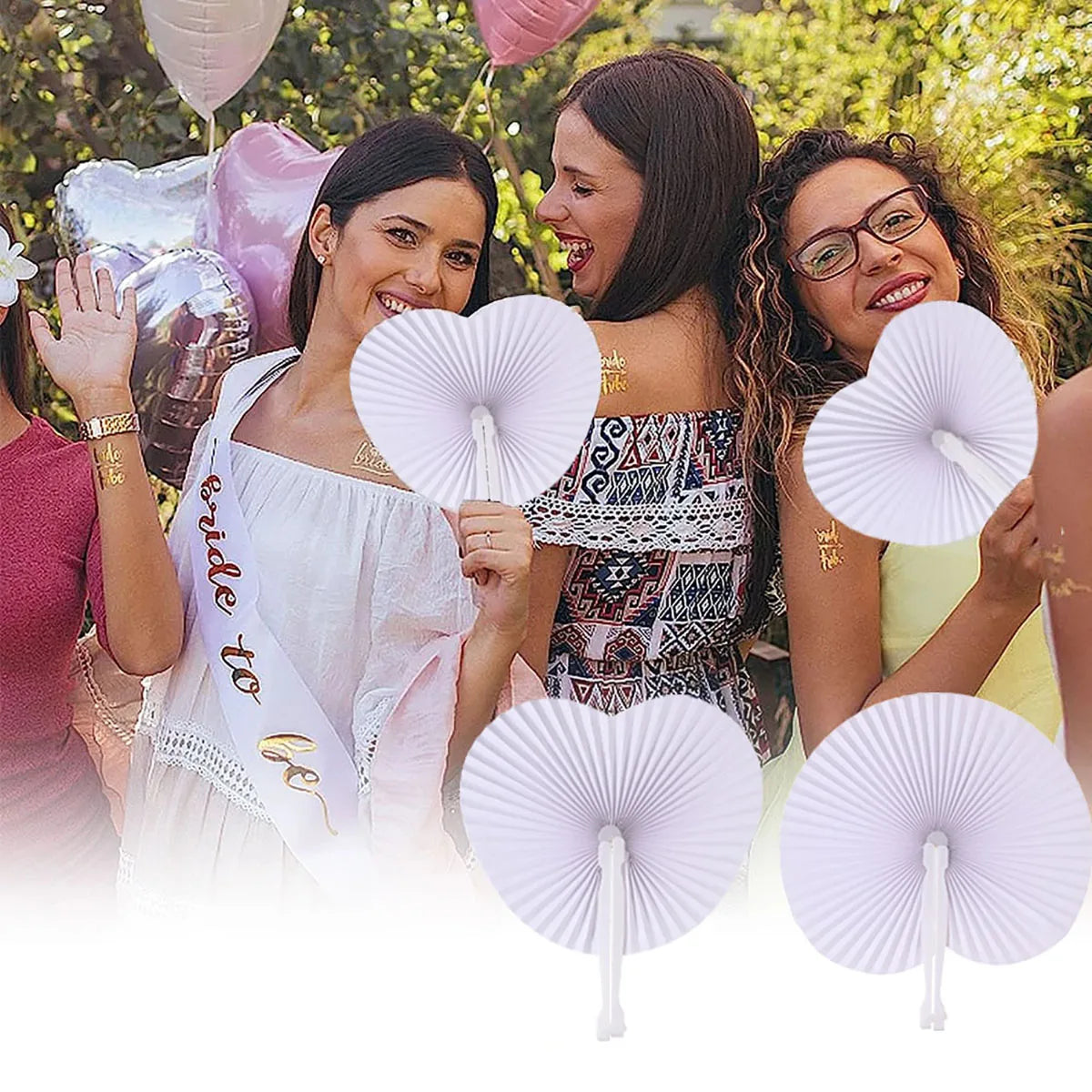 Three women smiling while holding heart-shaped paper folding fans for parties
