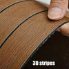 Close-up of a roll of brown wood grain self-adhesive wallpaper showing 3D stripes being unrolled.
