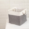 A set of four fabric storage cubes with metal frames in gray and white are displayed on a white surface.