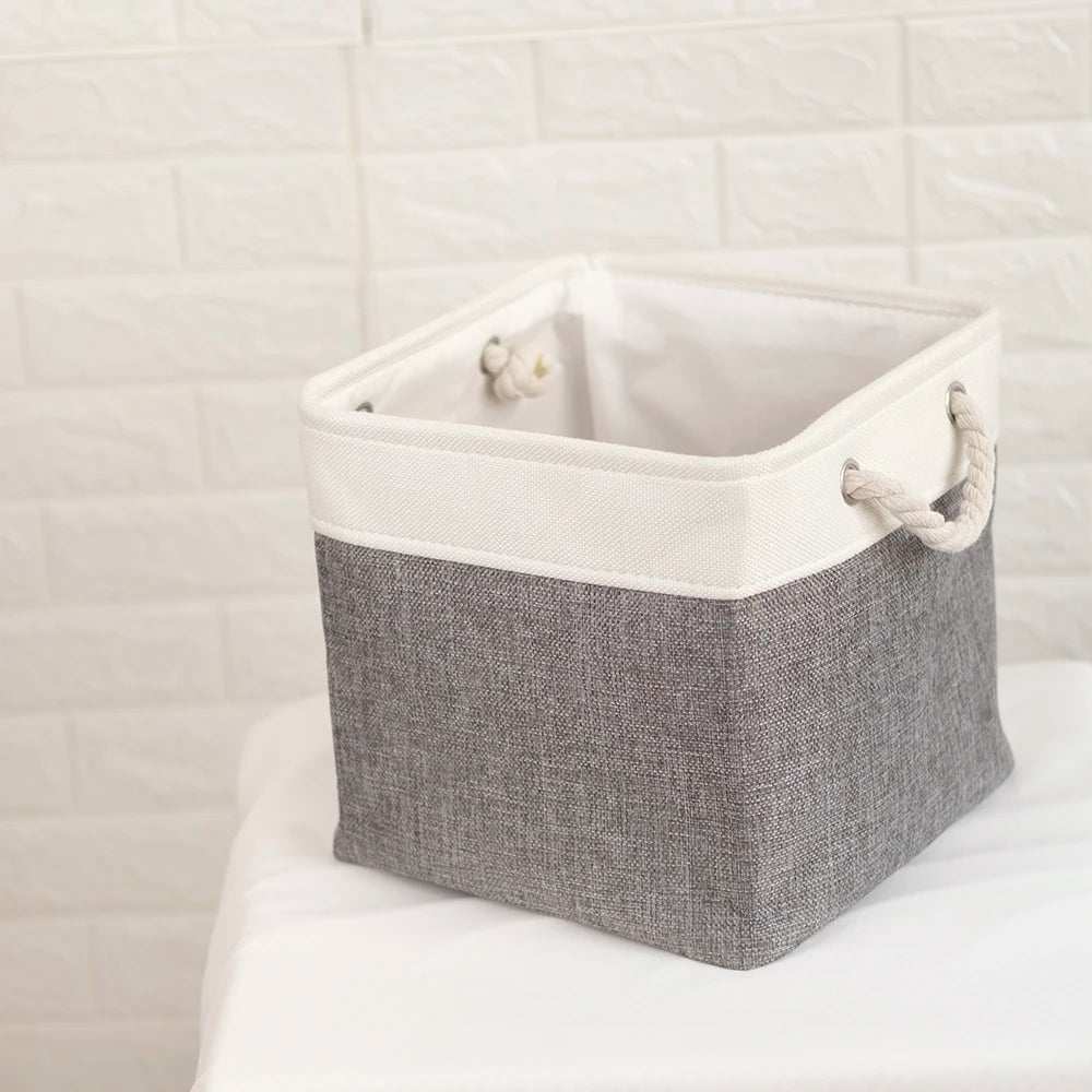 A set of four fabric storage cubes with metal frames in gray and white are displayed on a white surface.