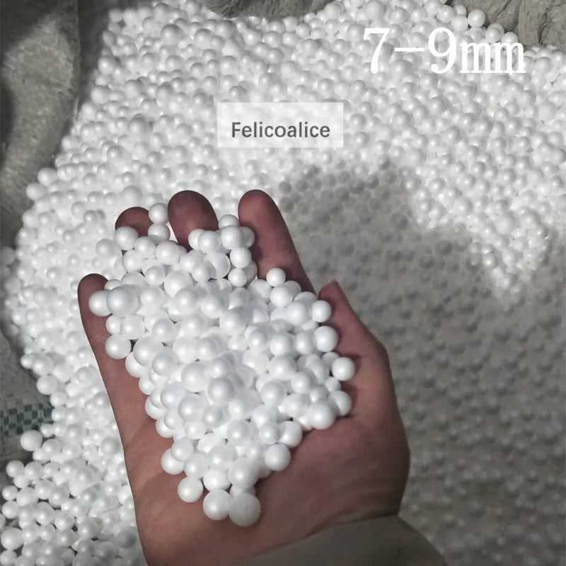 A hand holds a pile of white Felicoalice foam beads for crafting and decoration.