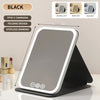 A black USB rechargeable vanity mirror with a folding design and stepless dimming feature is displayed on a stand.
