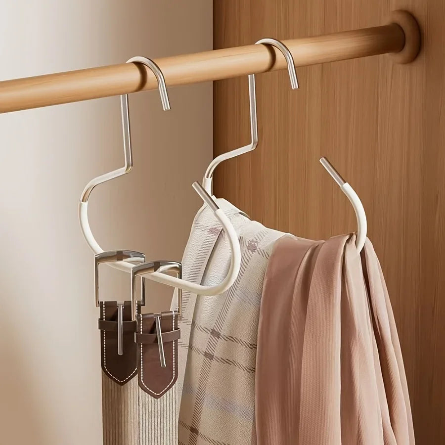 A set of metal hat storage hooks hanging from a wooden rod against a light-colored wall.