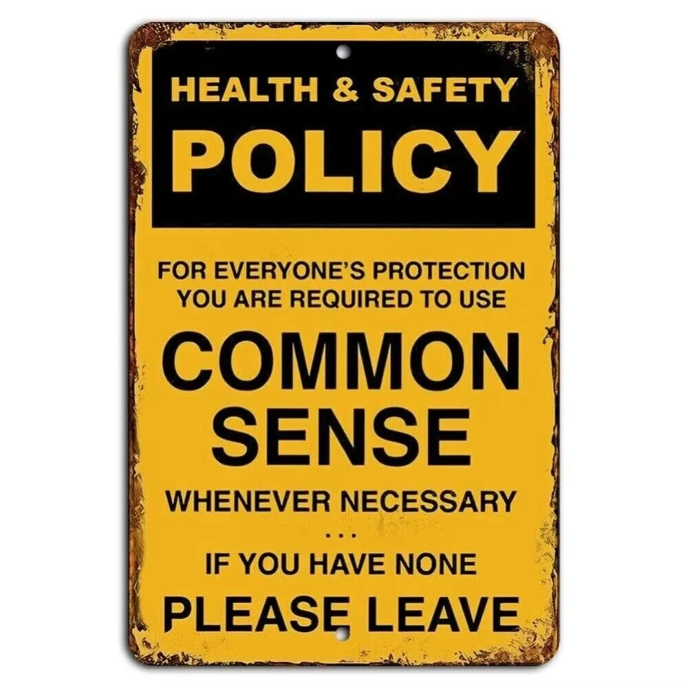 A vintage yellow metal sign with black text that reads Health & Safety Policy and Common Sense.