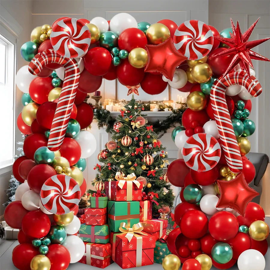 A festive balloon decoration set featuring red, gold, and green balloons arranged around a Christmas tree.