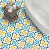A patterned floor featuring white, yellow, and teal floral designs with a wooden tray and soap on the ground.