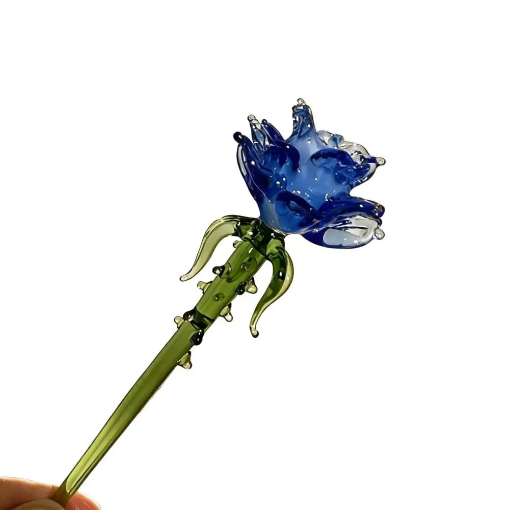 Handcrafted blue glass flower sculpture with a green stem and leaves