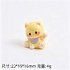 A small yellow resin cat keychain with pink accents and a purple collar.