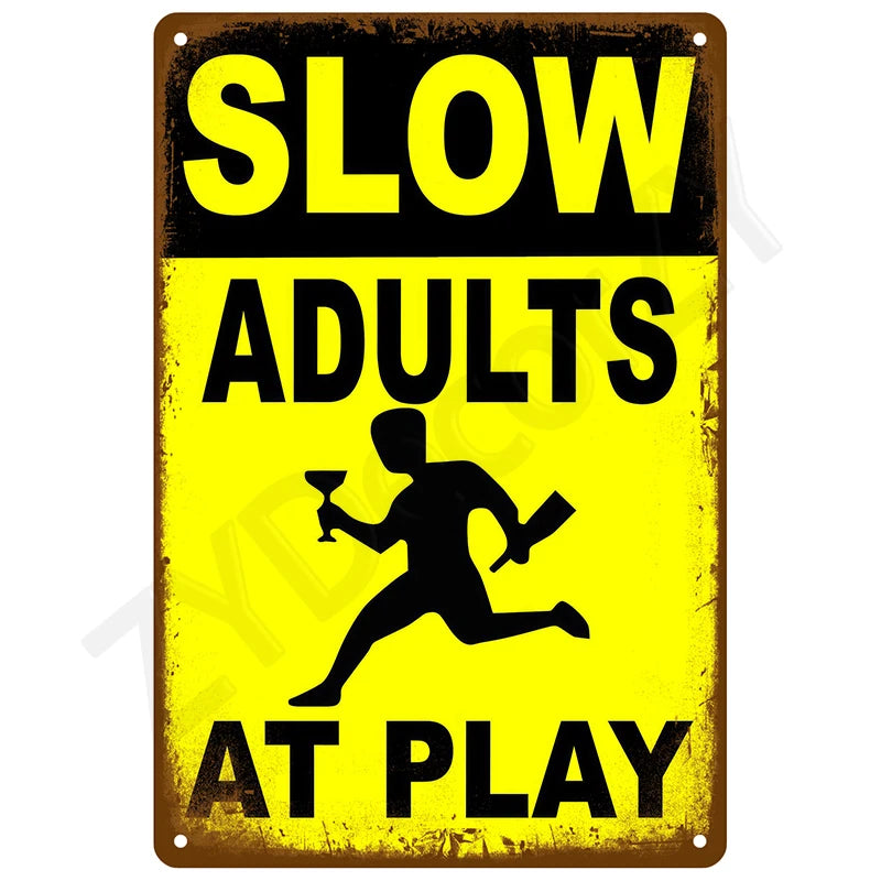 A vintage yellow and black warning sign that reads SLOW ADULTS AT PLAY.