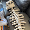 A white wearable dinosaur skeleton costume pillow showing the head and spine.