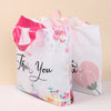 White floral thank you gift bags with pink ribbon handles