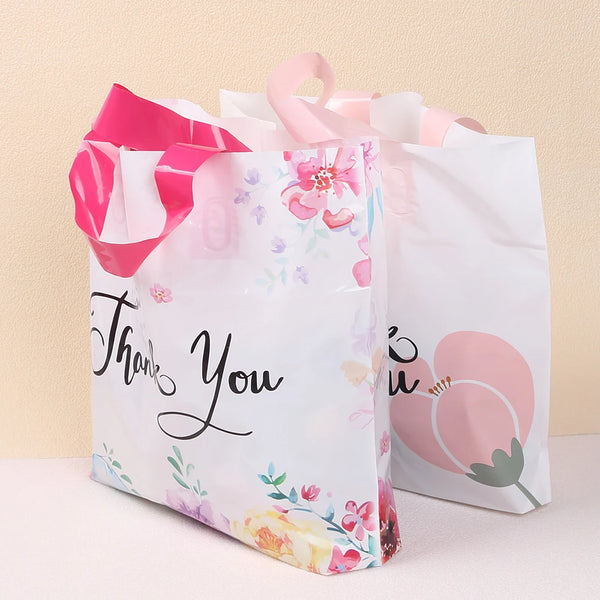 White floral thank you gift bags with pink ribbon handles
