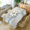 Elegant white lily flower rectangular tablecloth displayed on a wooden dining table with chairs.
